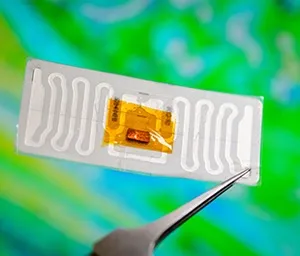 Tweezers holding a white barcode sticker