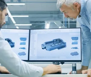 Engineers discussing a 3D model on computer screens