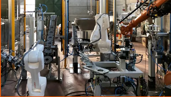 Robot cell to assemble spring holding boxes